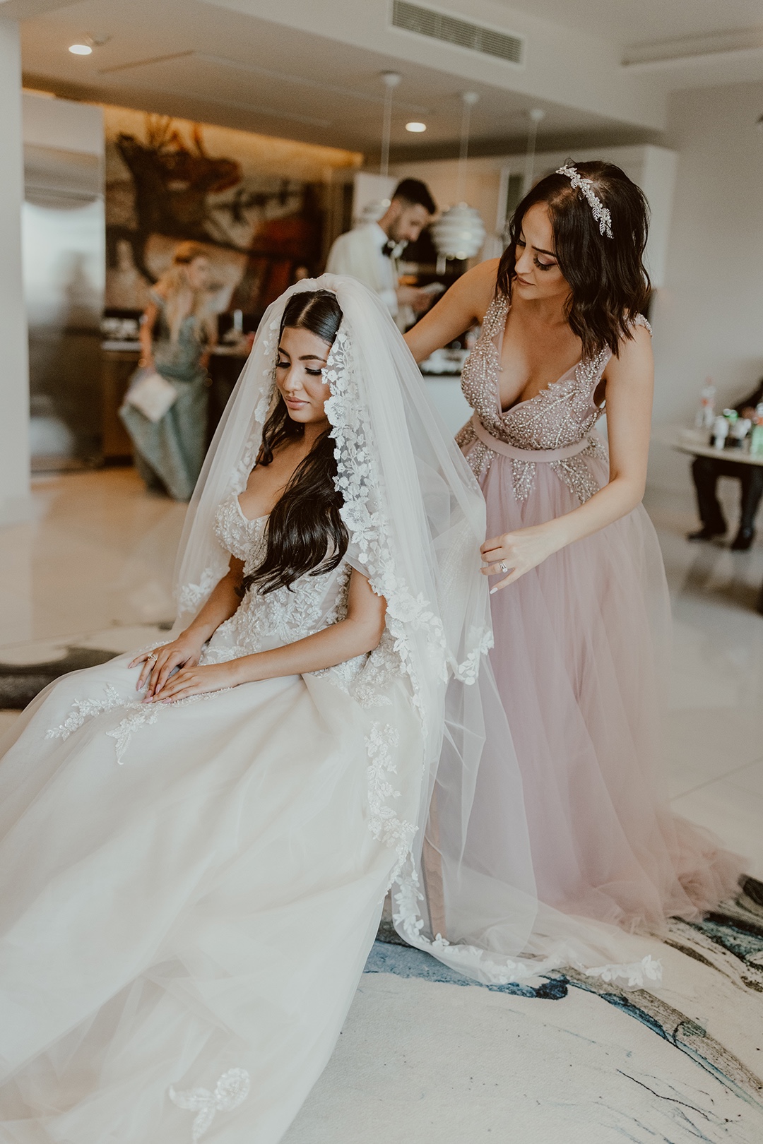 Maid of honor placing lace veil 
