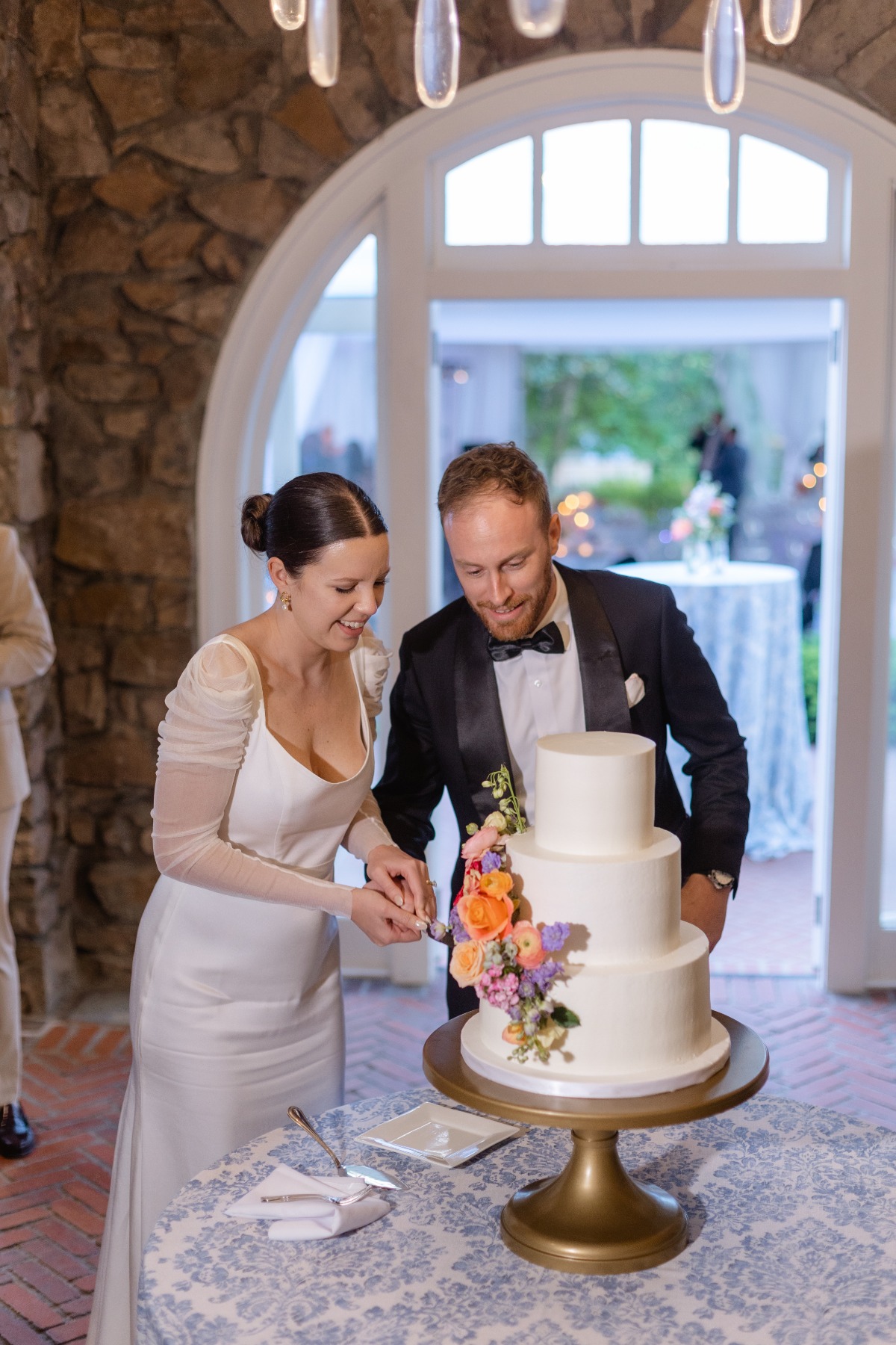 Bride and groom cutting floral cake 