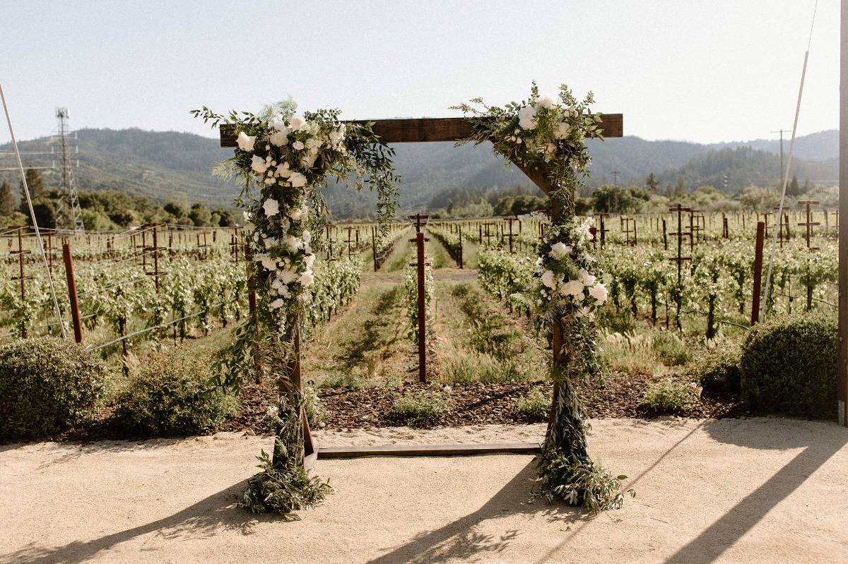 wood ceremony arbor with white rose florals