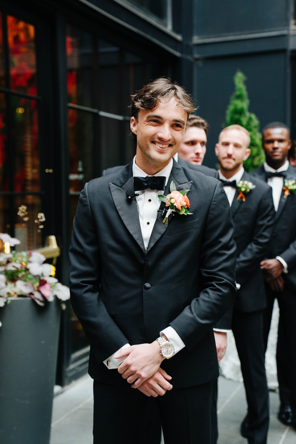 groom in tux with orange boutonnière 