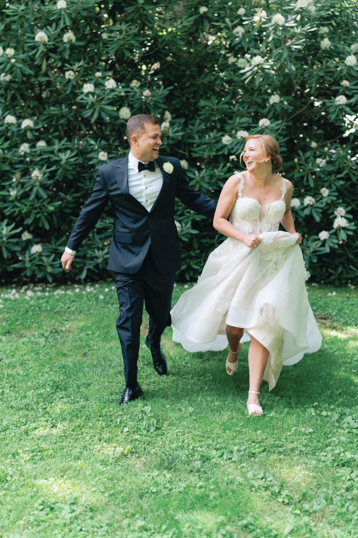 bride and groom frolicking in the grass