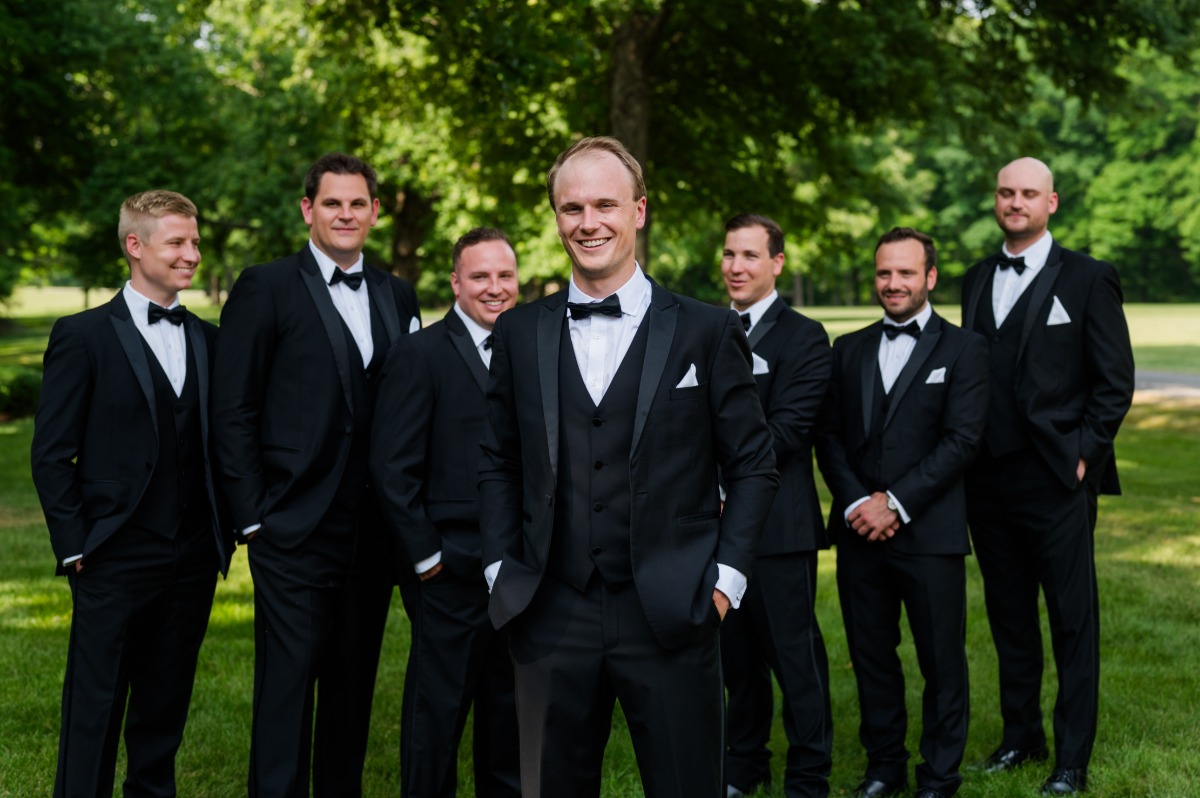 groom and groomsmen in three piece tuxedos