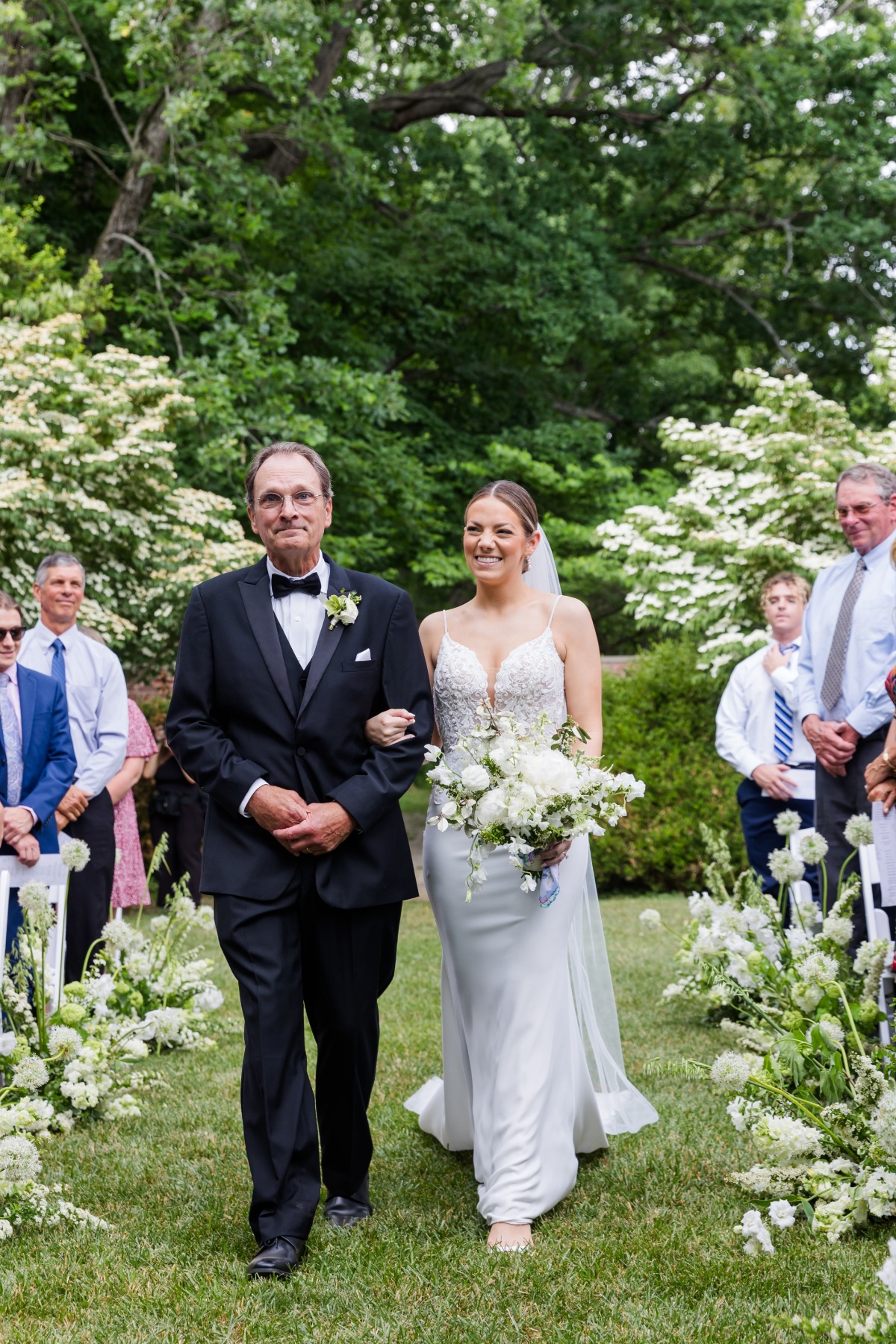 bride walking down garden aisle with father