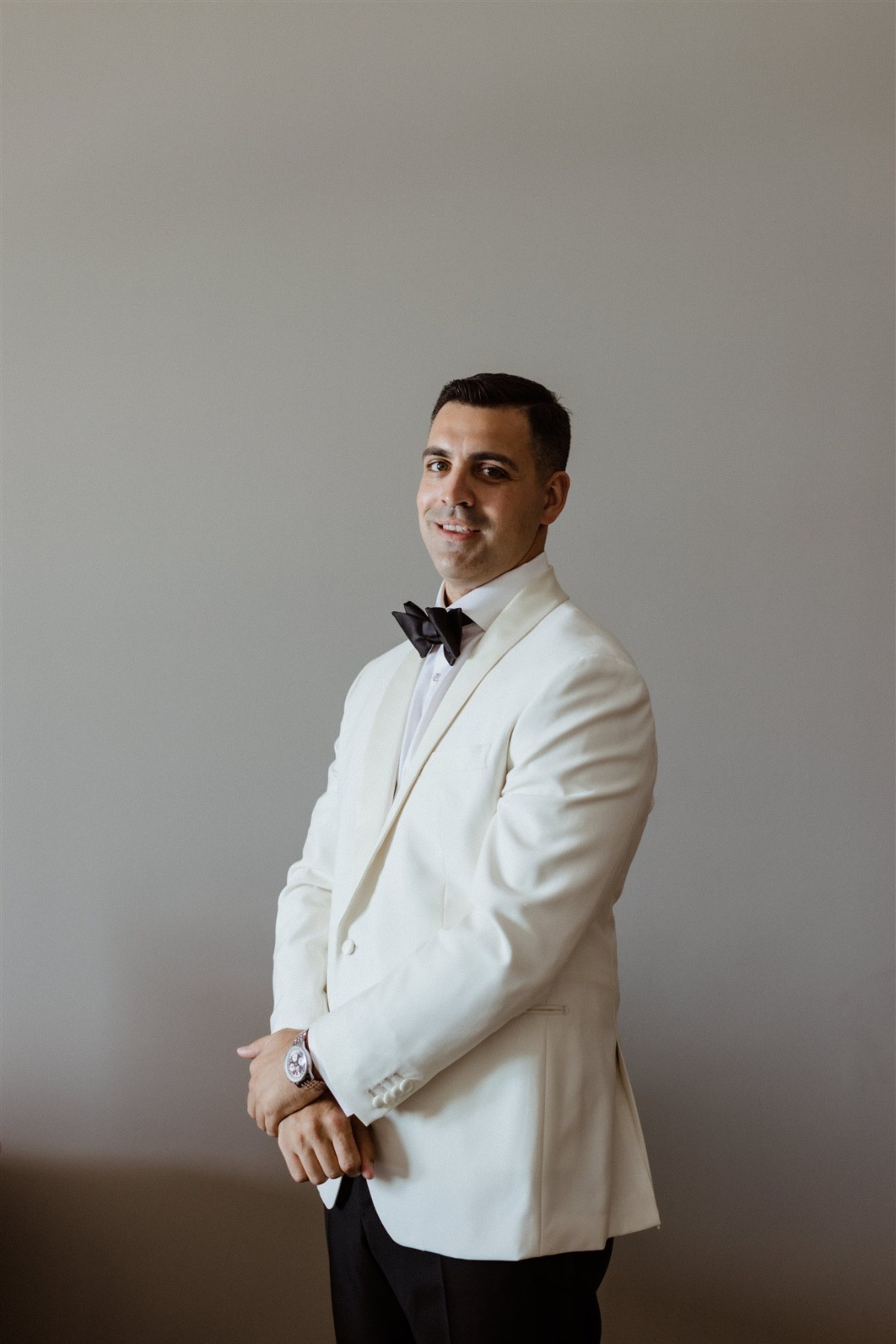 groom in white dinner jacket and black tie