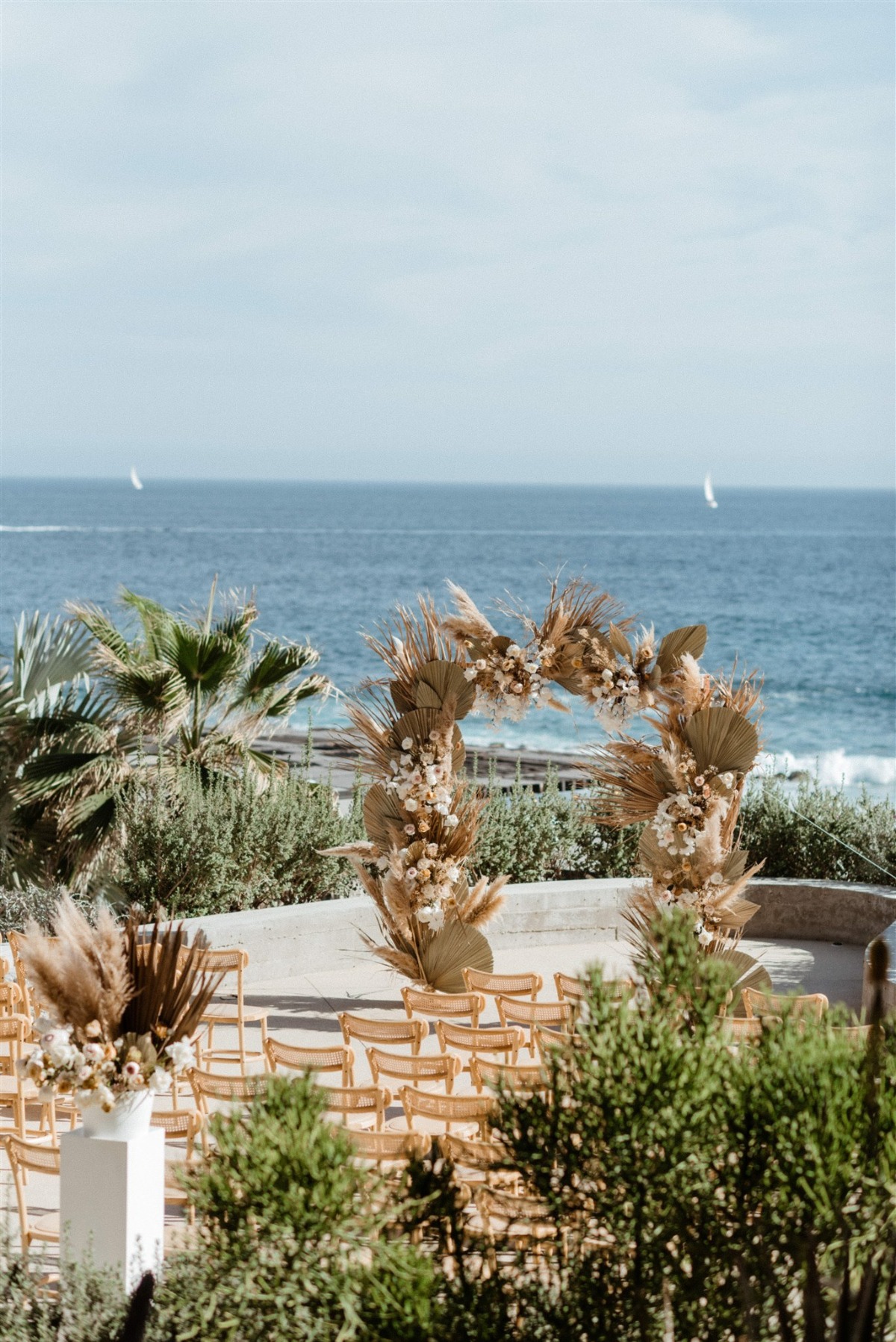 beach front wedding with palm frond arch