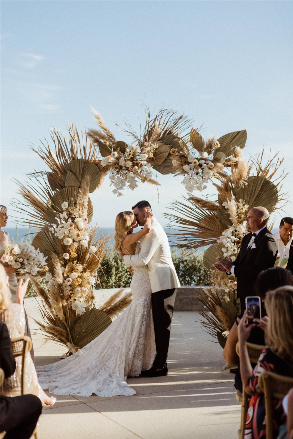 tropical wedding ceremony with dried floral arch