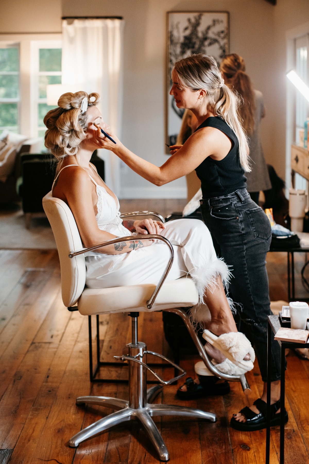 blonde bombshell bride getting her hair done for wedding