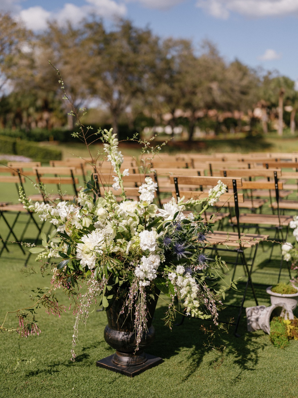 wood chairs and white florals for wedding ceremony