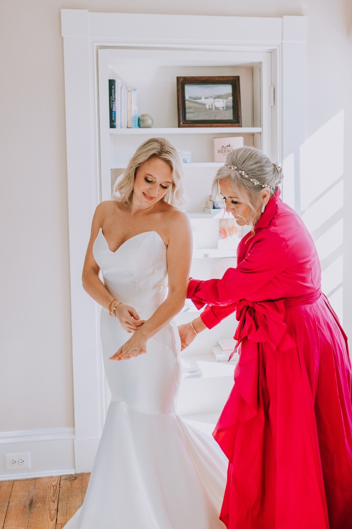 Mom helping bride into dress