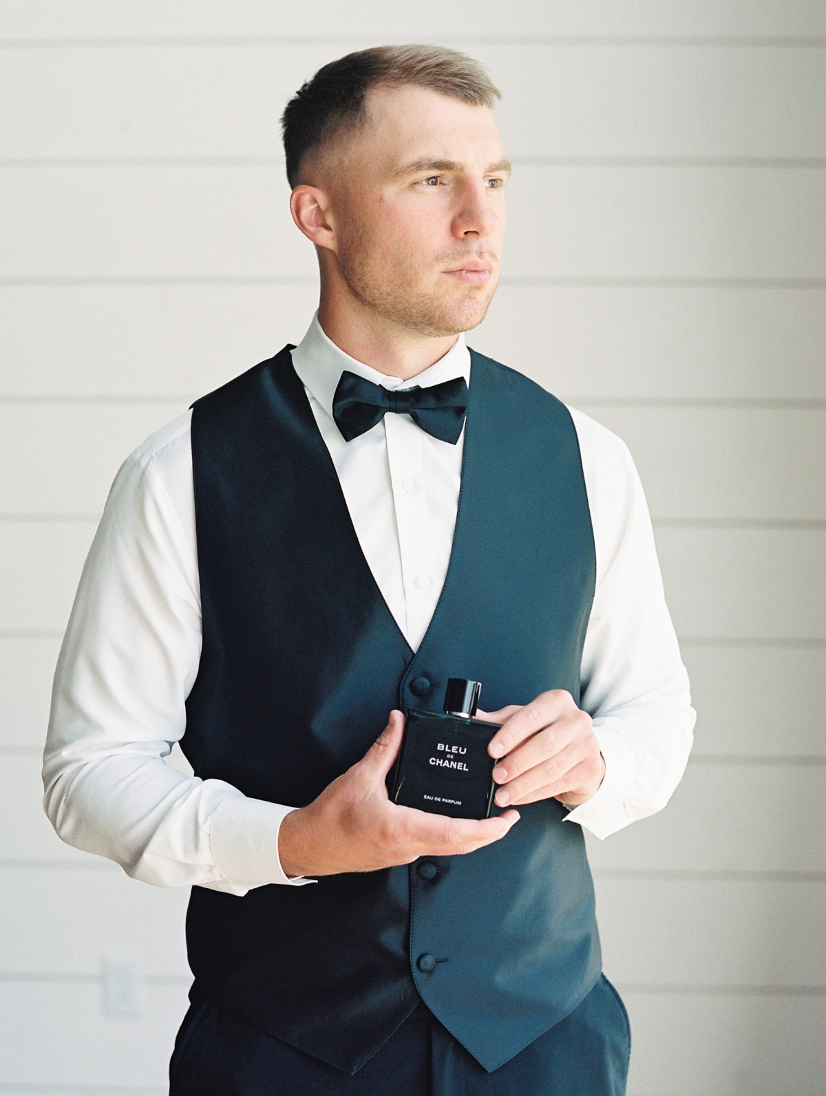groom in vest with cologne 