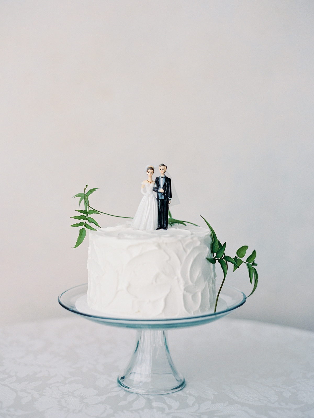 simple buttercream cake with vintage bride and groom topper