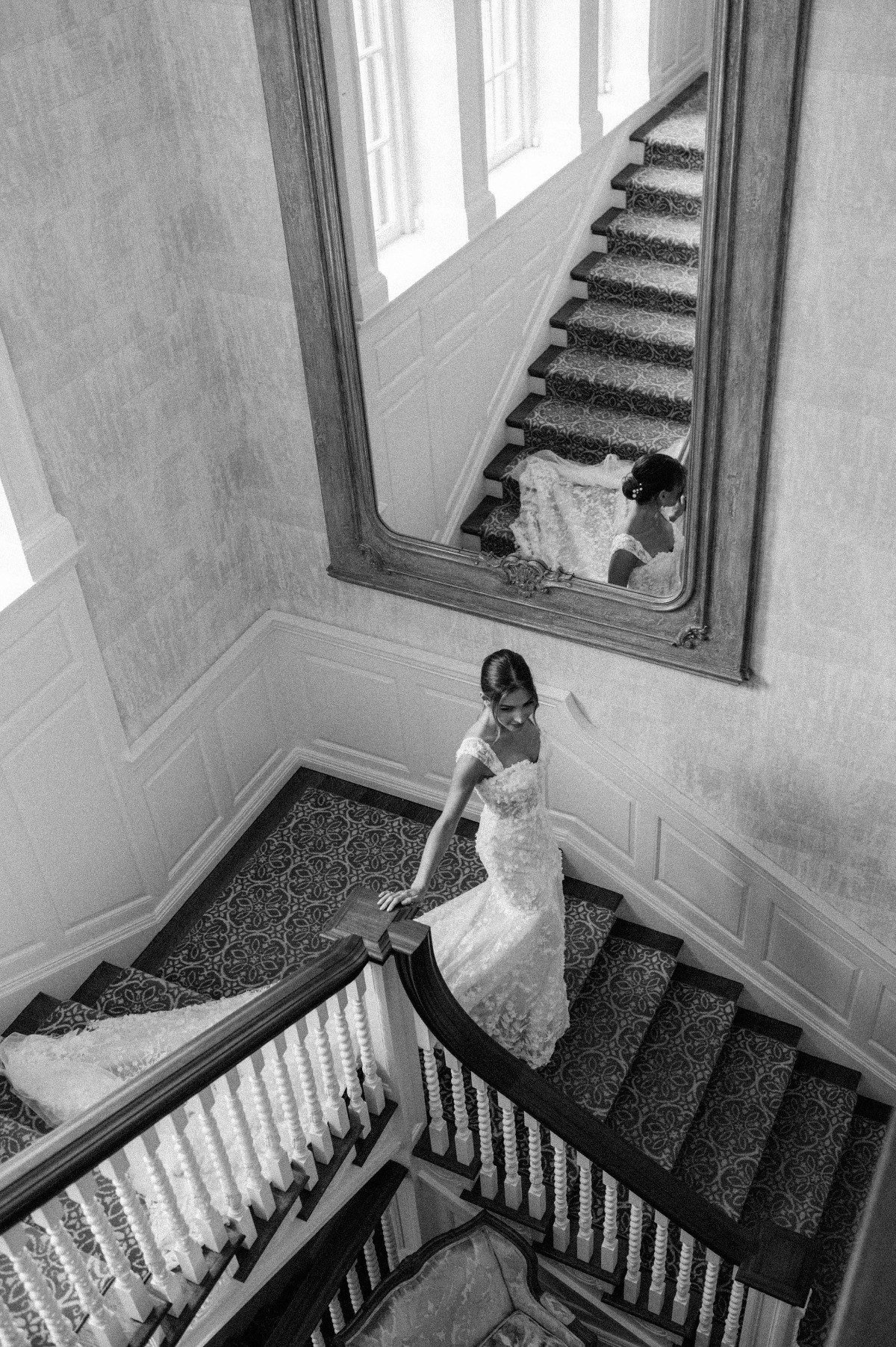 Elegant bride walking down manor staircase 