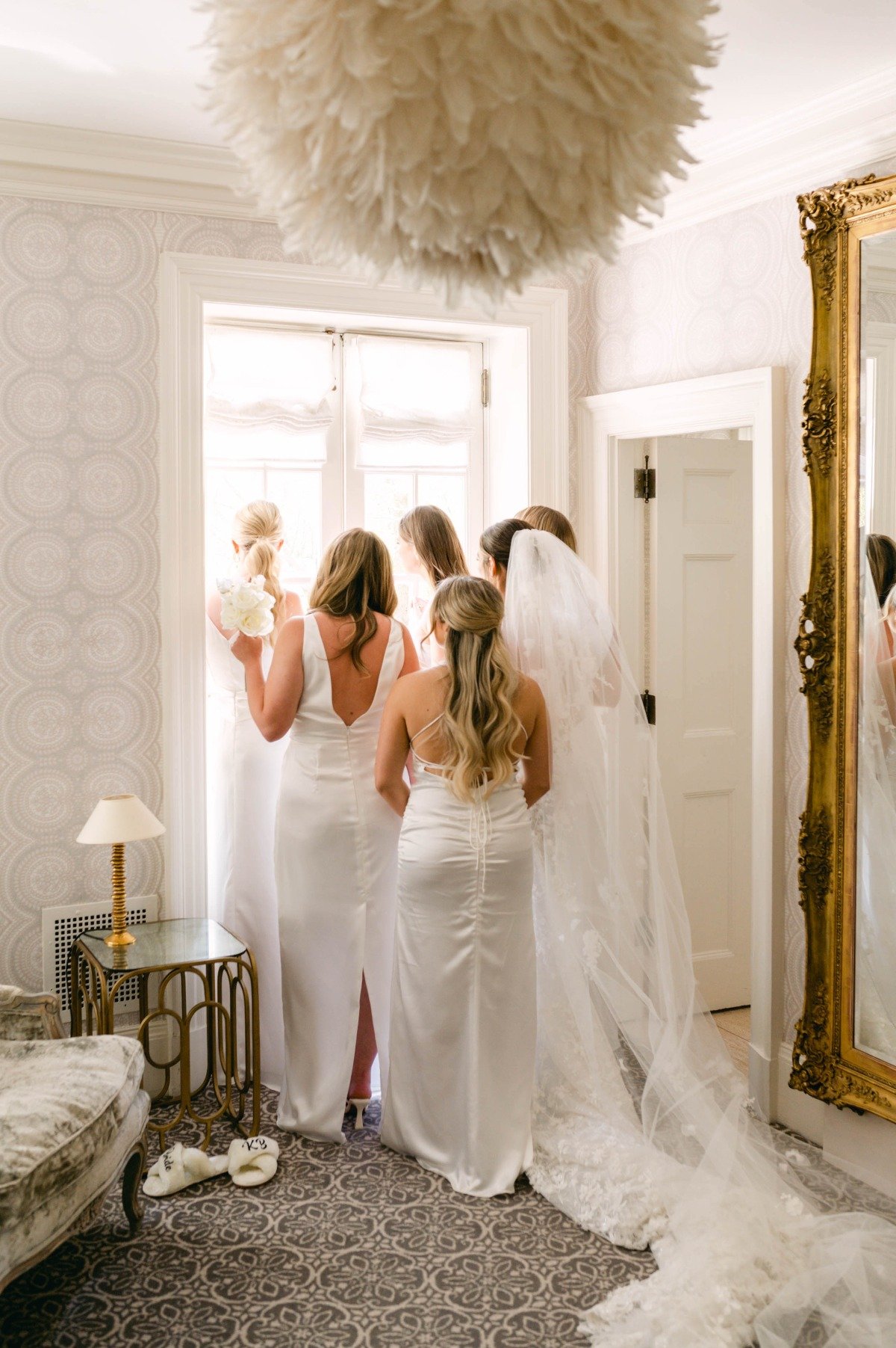 Bride and bridesmaids looking out the window