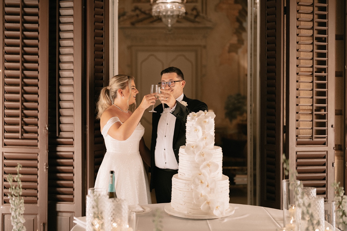 Bride and groom toast at cake table 