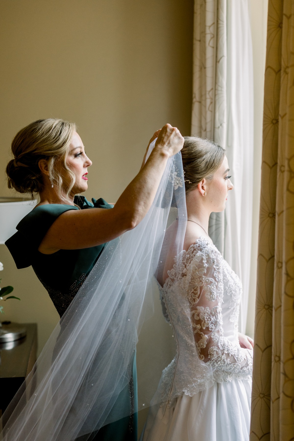 Mother of bride putting on veil 