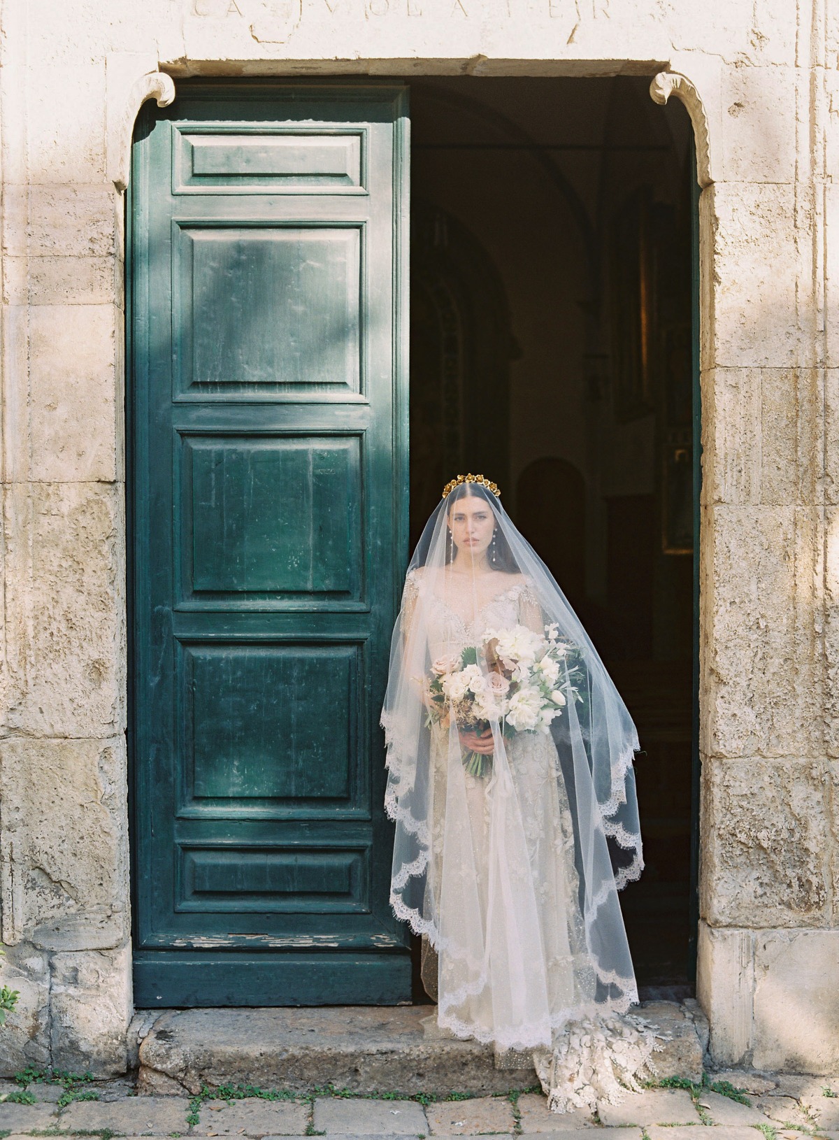 Ethereal Italian bride leaning on vintage green door 