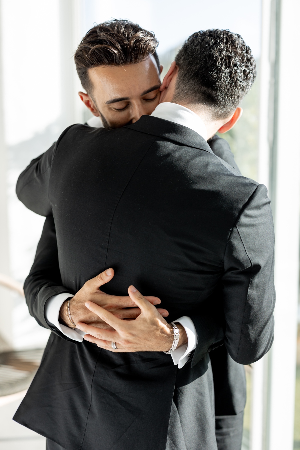 Two grooms embracing after destination wedding ceremony 