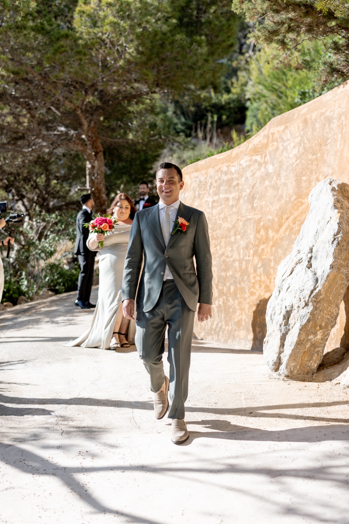 Ibiza groomsmen walking down outdoor ceremony aisle 