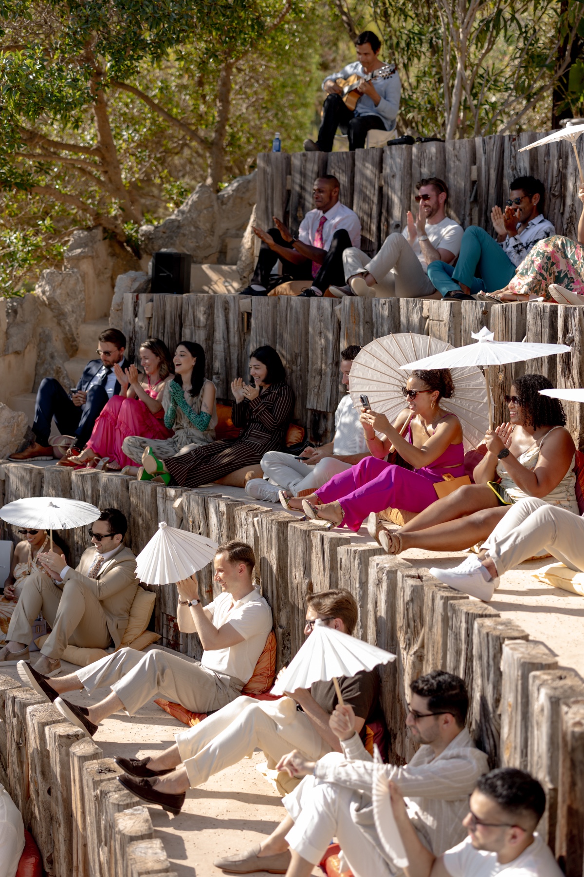 Fashionable wedding guests watching wedding ceremony in Ibiza