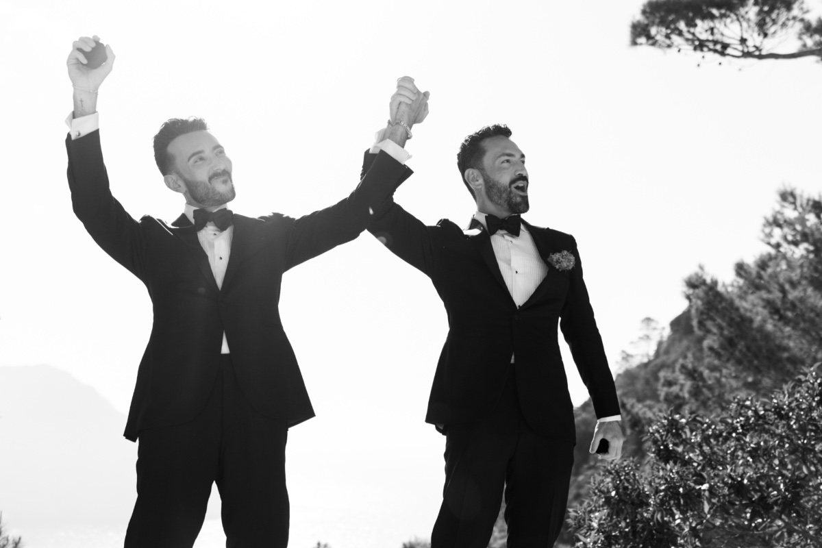 Two grooms cheering after first kiss in Ibiza Spain 
