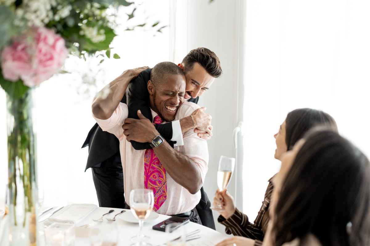 Joyful groom hugging wedding guest at Ibiza wedding 