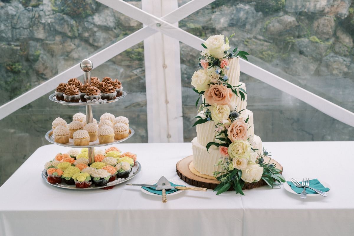 Modern wedding cake with floral themed pastel cupcakes 