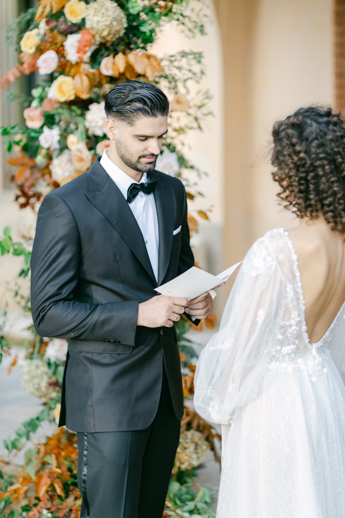 Elegant groom reading vows at timeless Greek wedding 