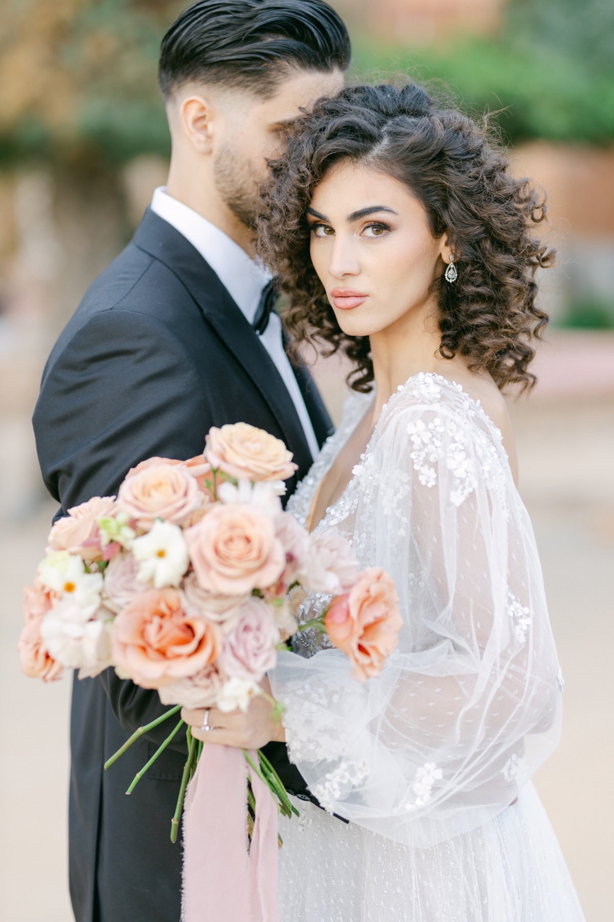 Romantic Greek bride holding bouquet in floral gown 