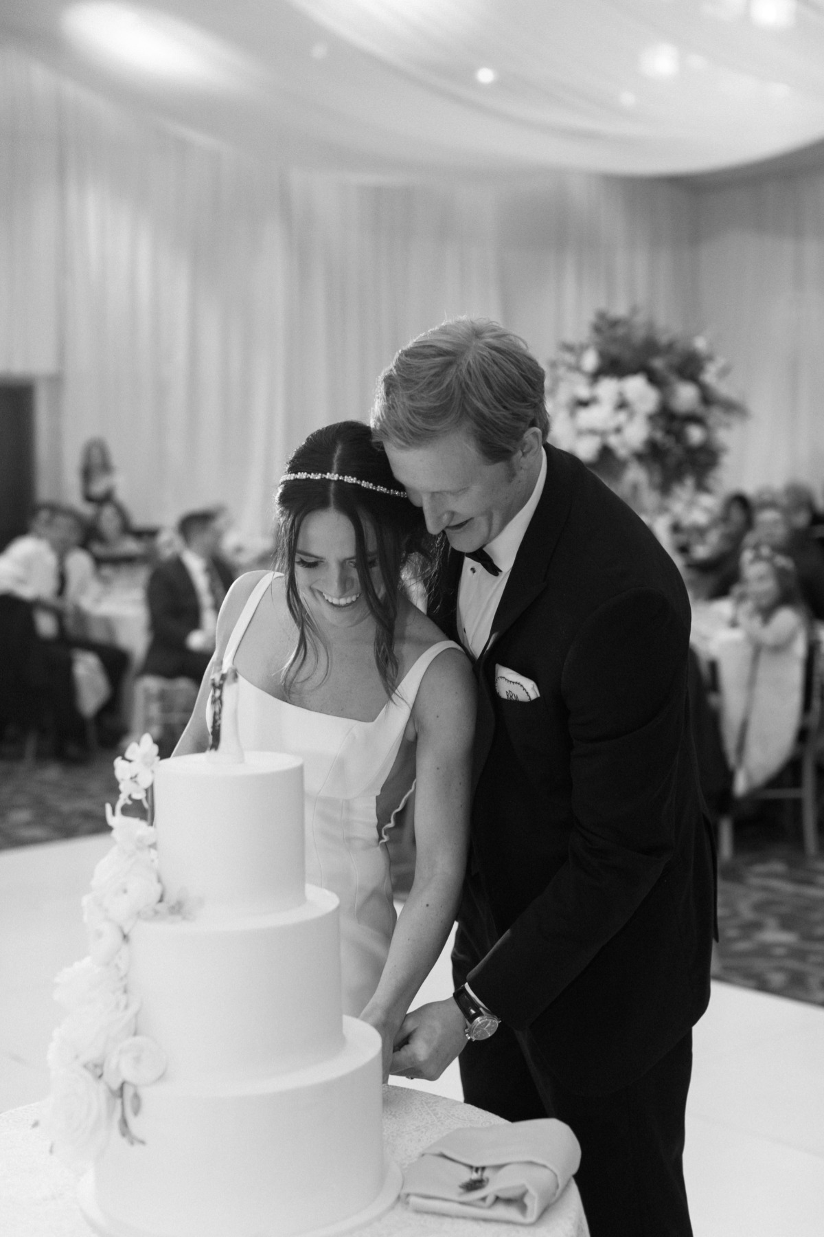 Newlyweds cutting simple classic wedding cake 