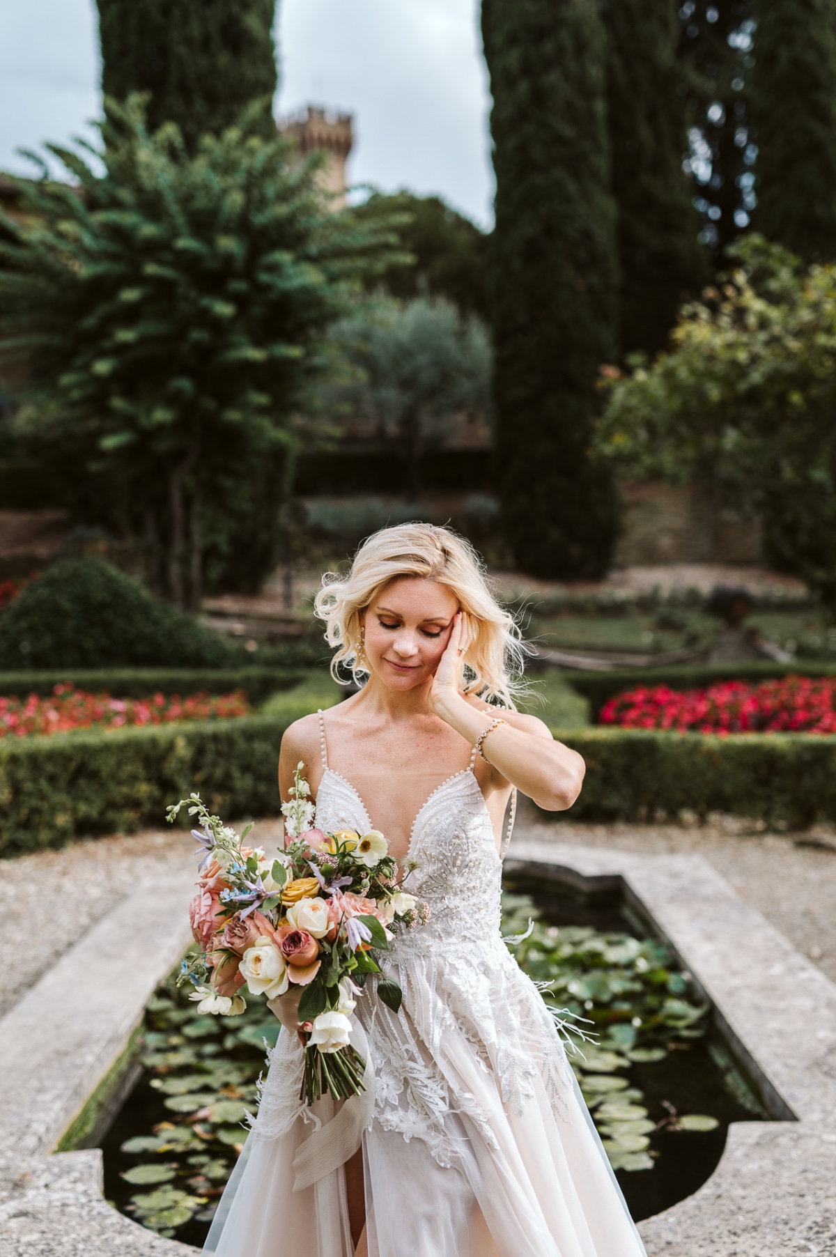 bride in feathered wedding gown with pastel bouquet