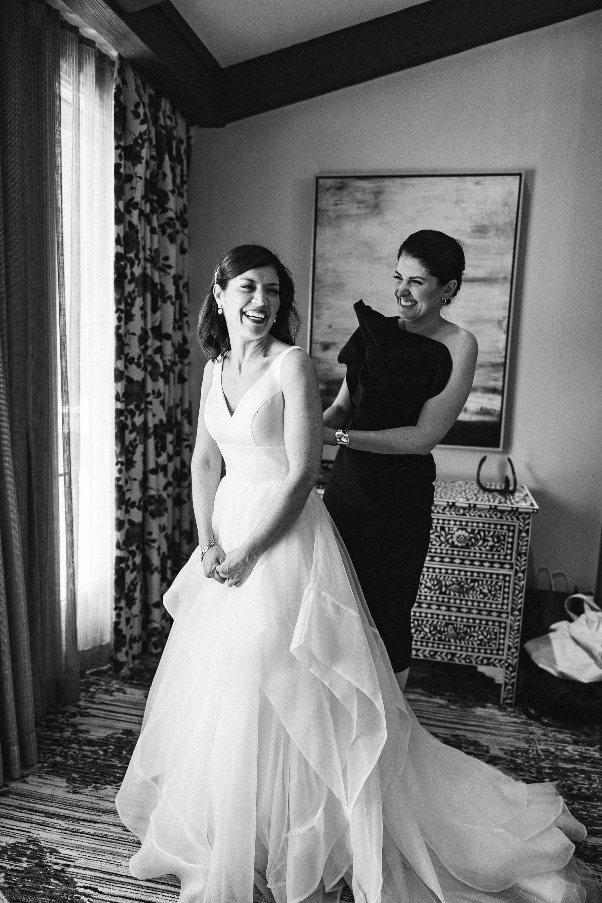 Bride getting dressed in ball gown with layers of tulle