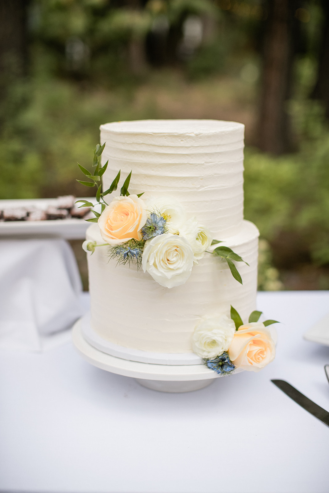 simple buttercream wedding cake with fresh flowers