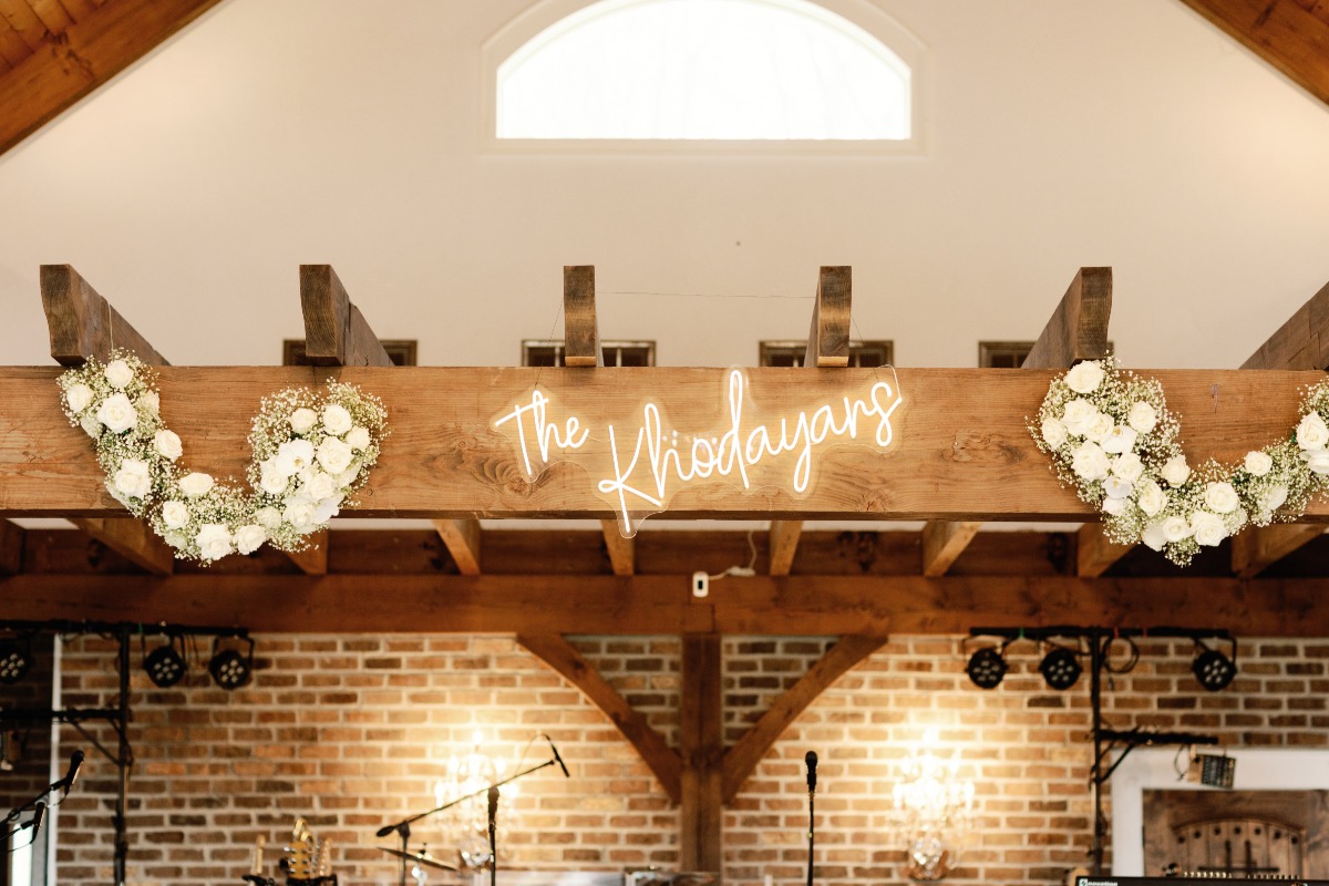 Neon lit wedding sign with married name above reception stage