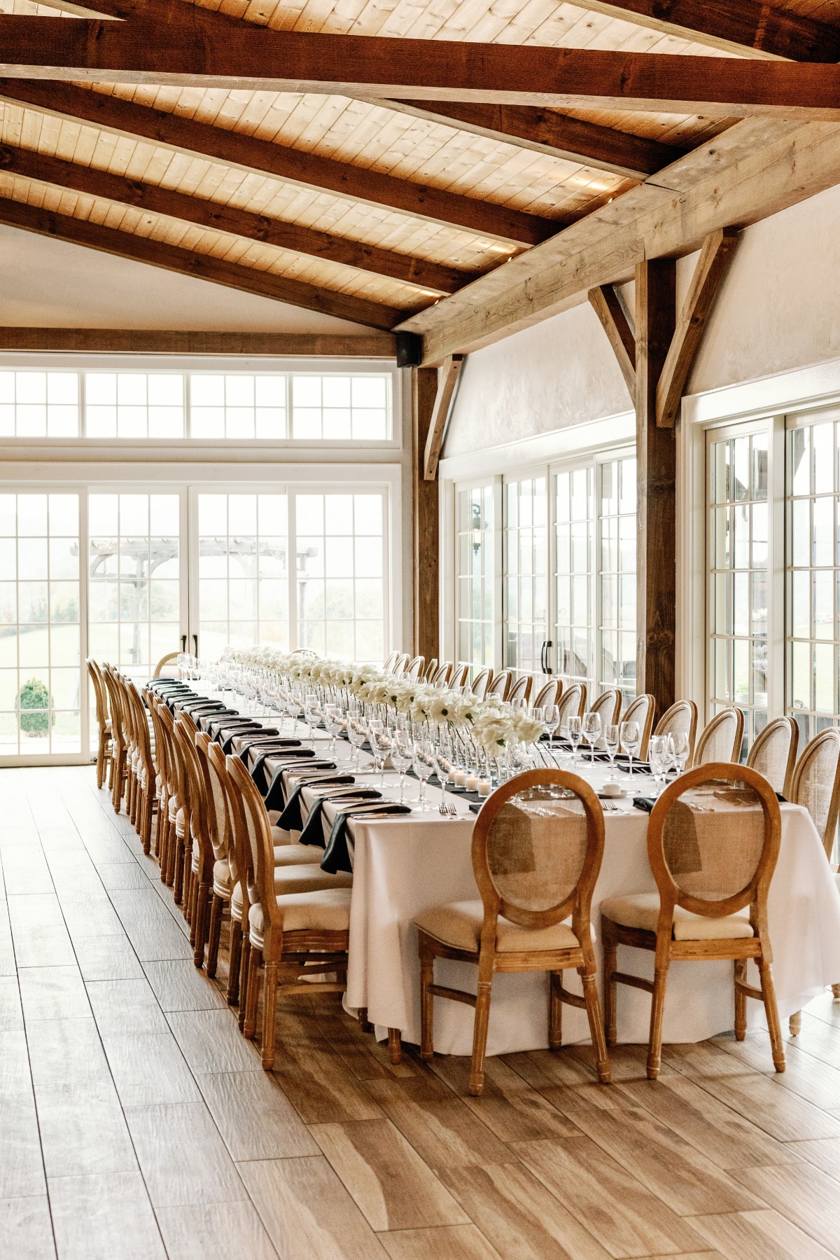 Long elegant wedding reception tables and wooden chairs