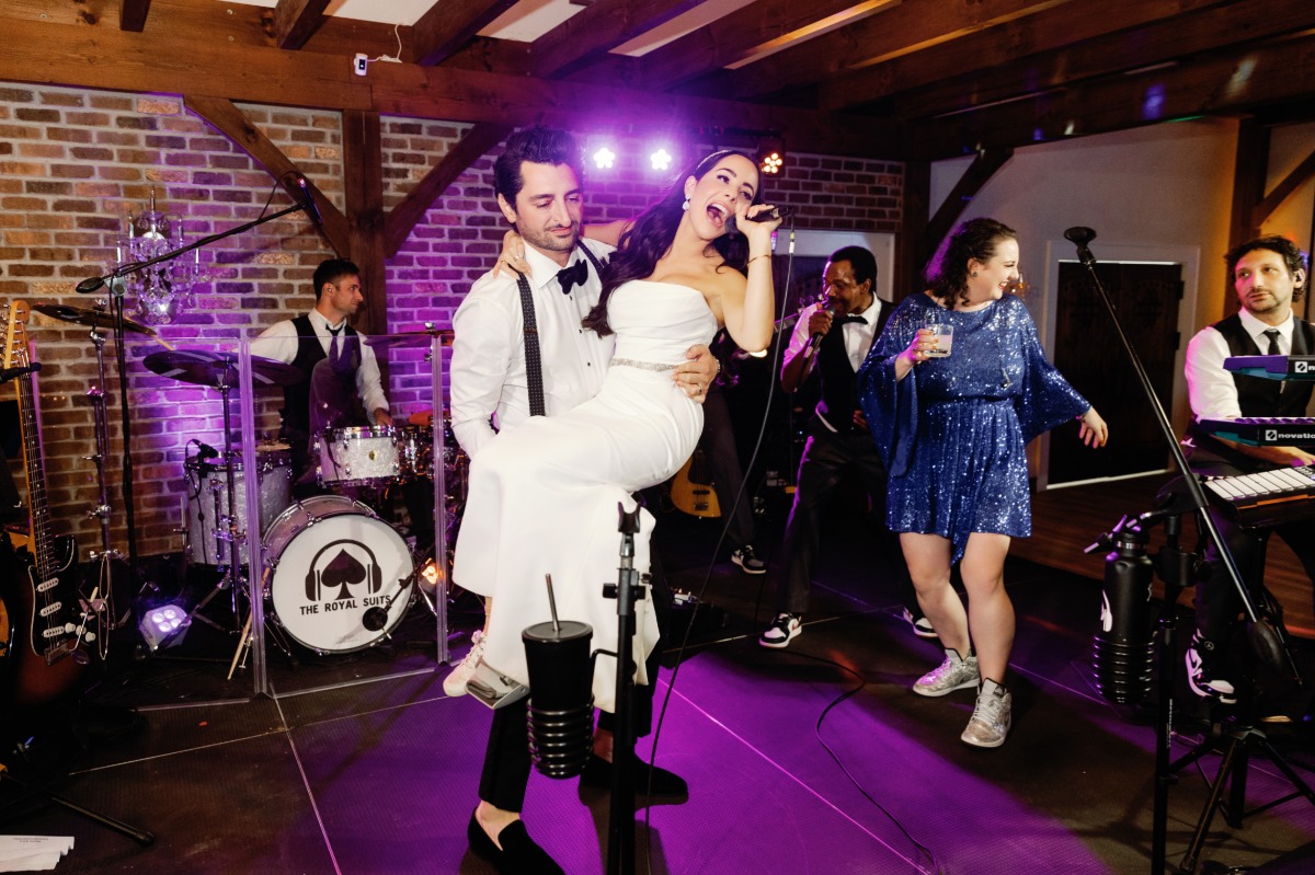 Bride singing into the live band's microphone during reception