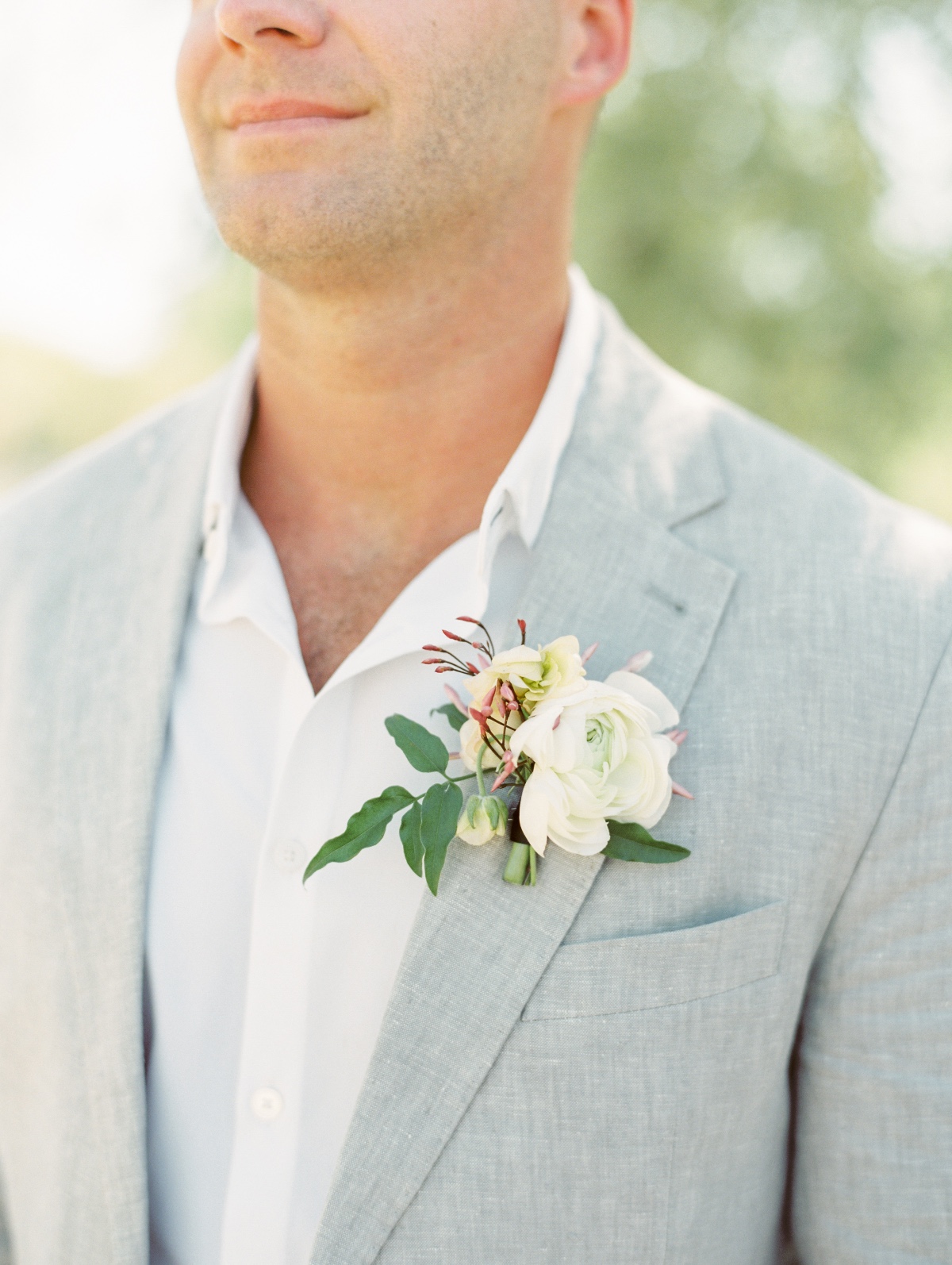 Grey suit groom with pastel white boutonniere 