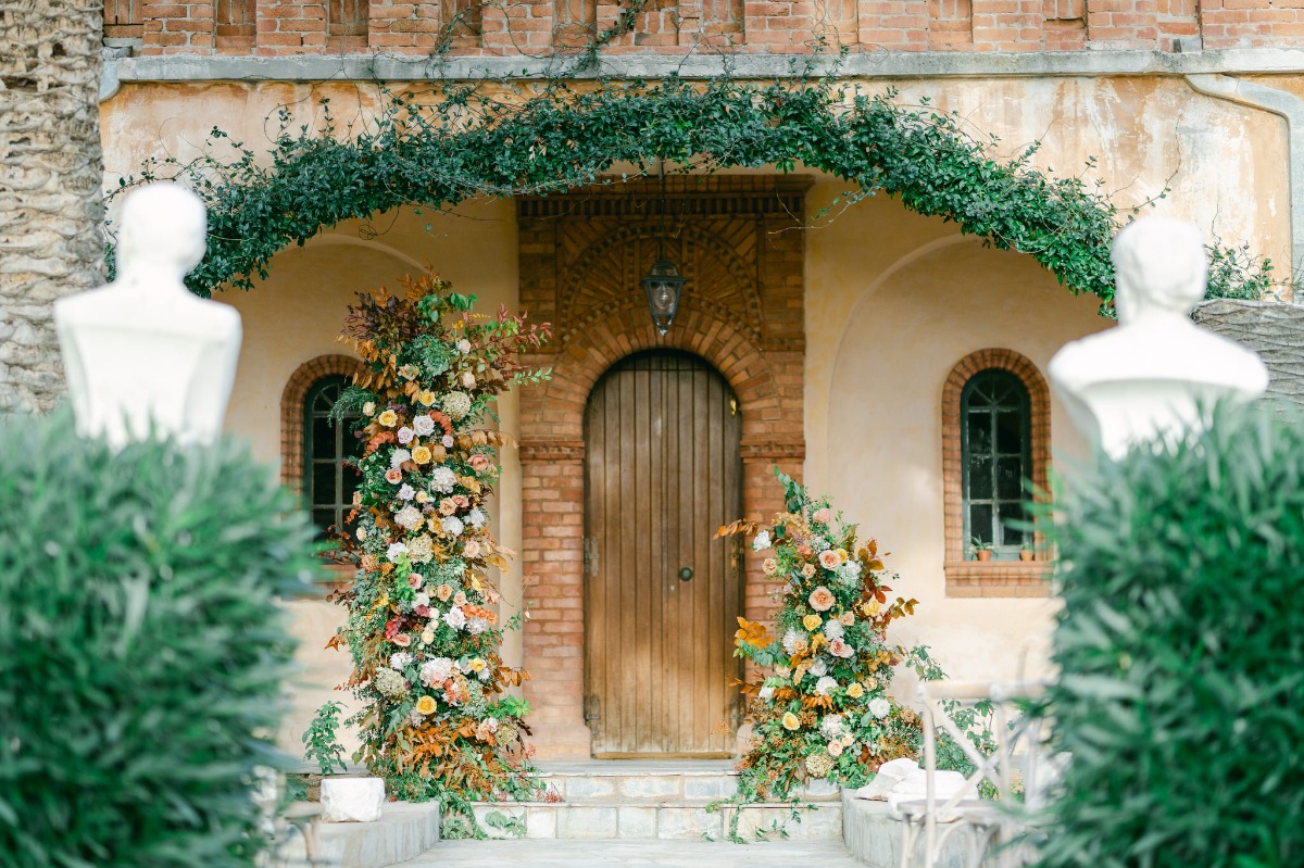 Romantic outdoor Greek wedding ceremony with standing florals
