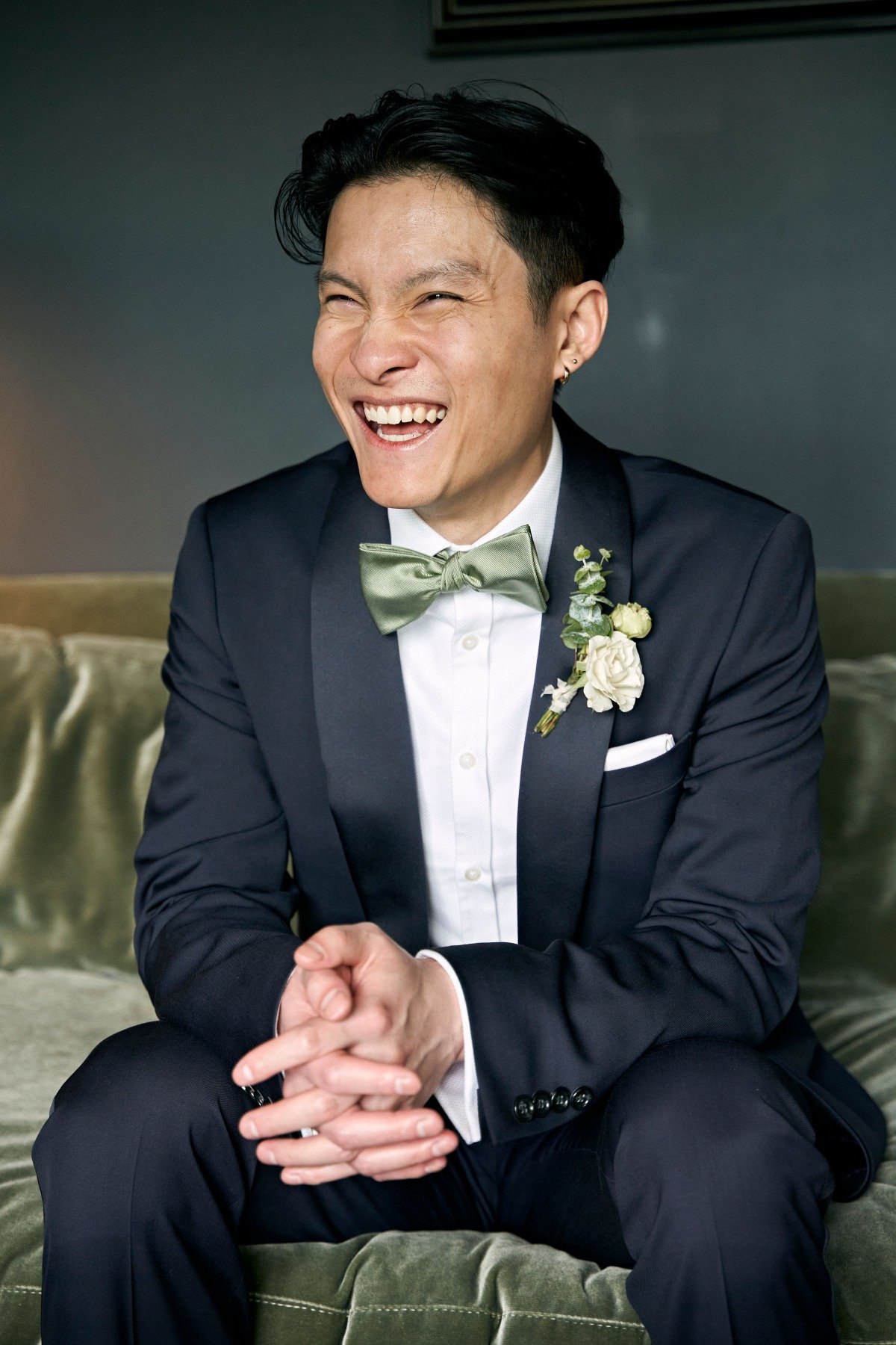 Handsome groom in olive green accented tuxedo and bowtie