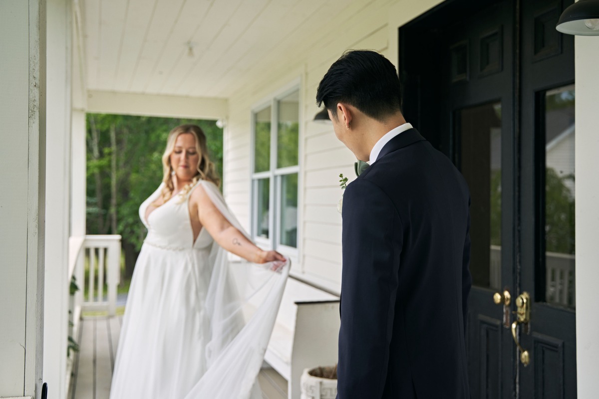 Bride showing cape dress at first look at Hudson Valley wedding 