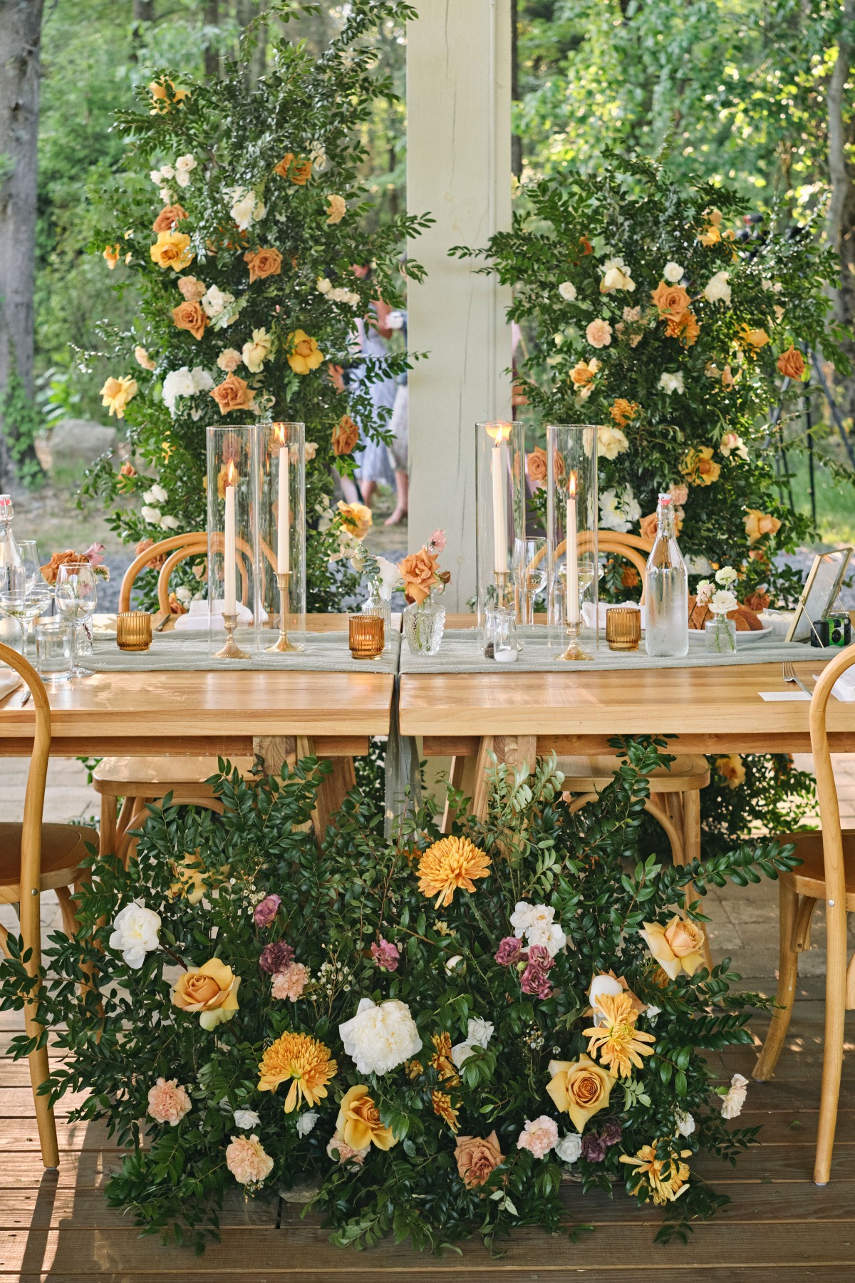 Warm floral and greenery filled sweetheart table at reception 