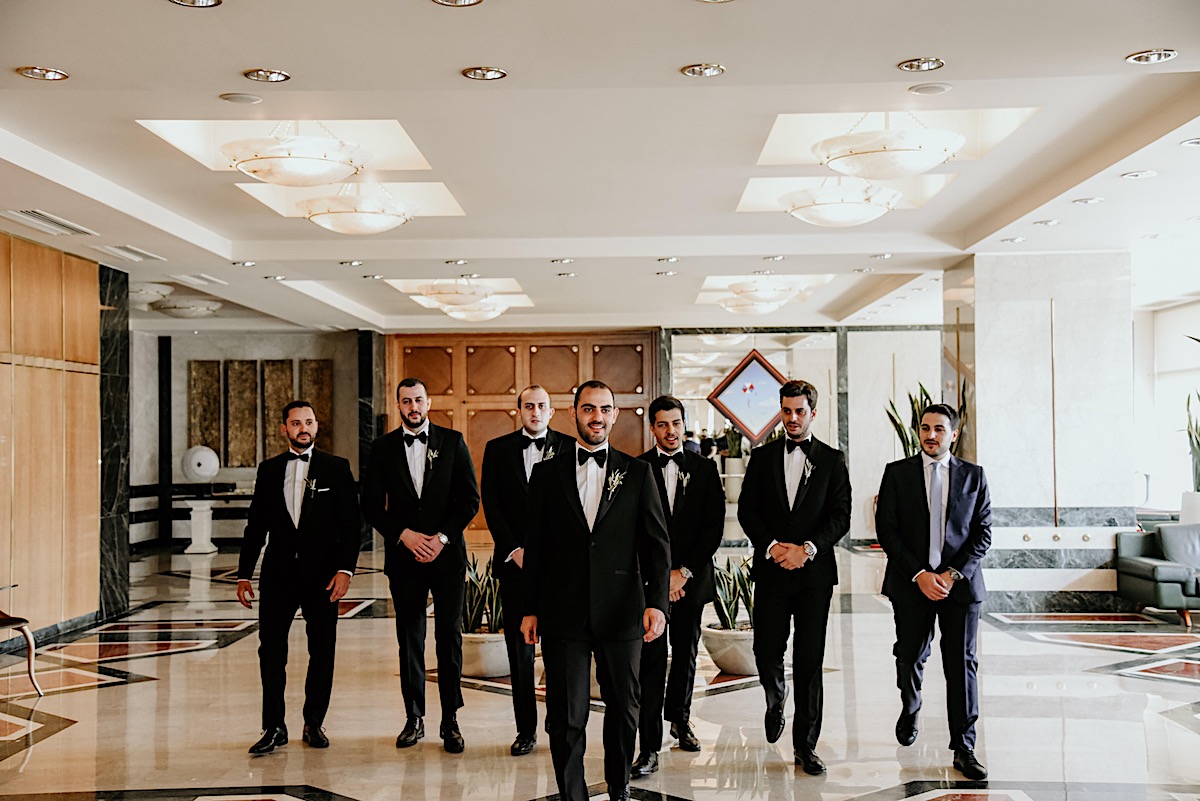 Groom and groomsmen in olive boutonnieres at Greek wedding 