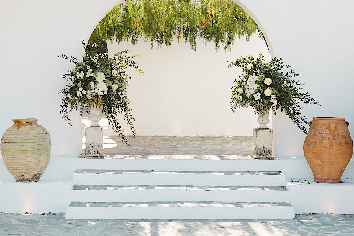 Modern white walled Greek destination wedding venue with florals