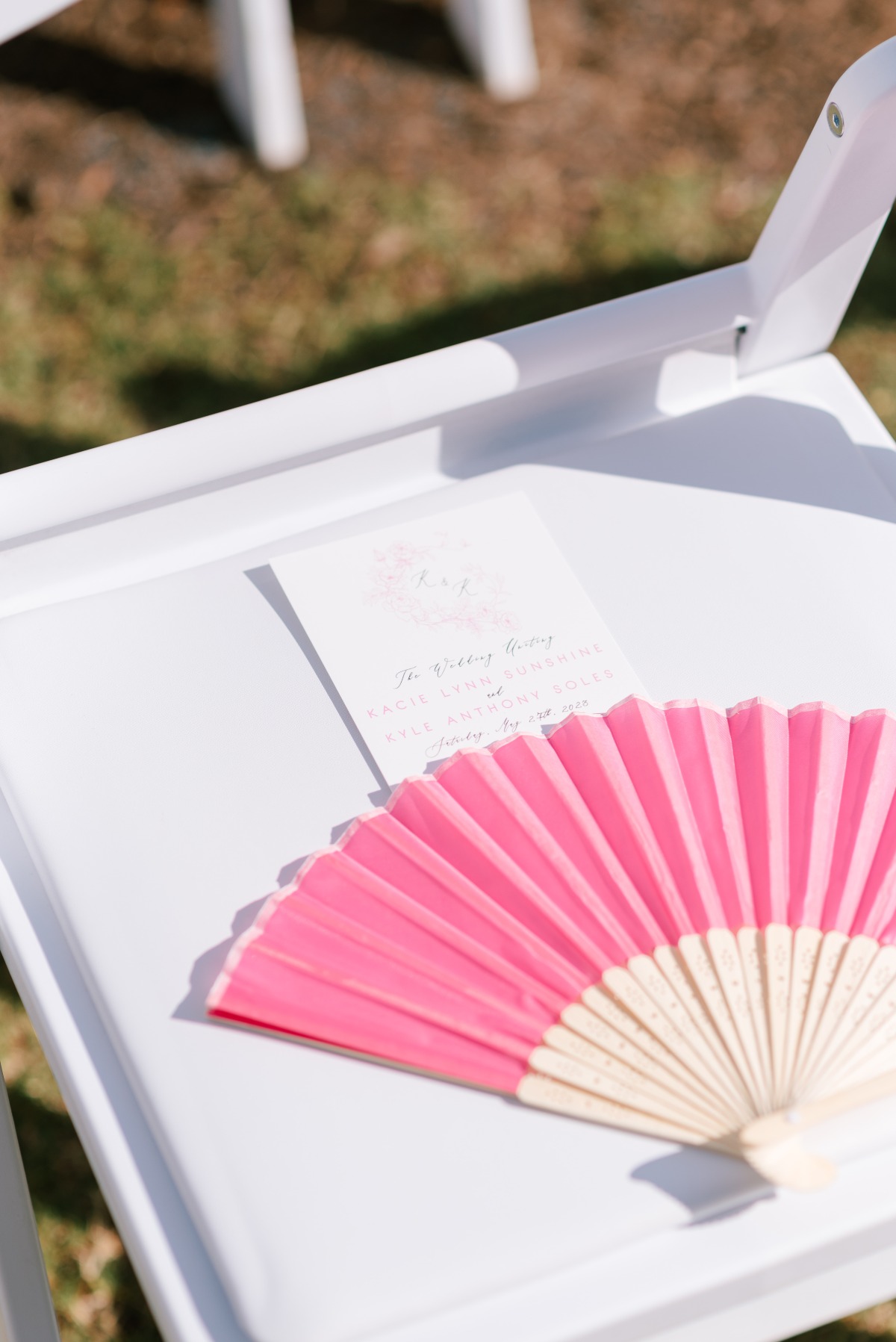 Hot pink fan and white floral program for ceremony seat