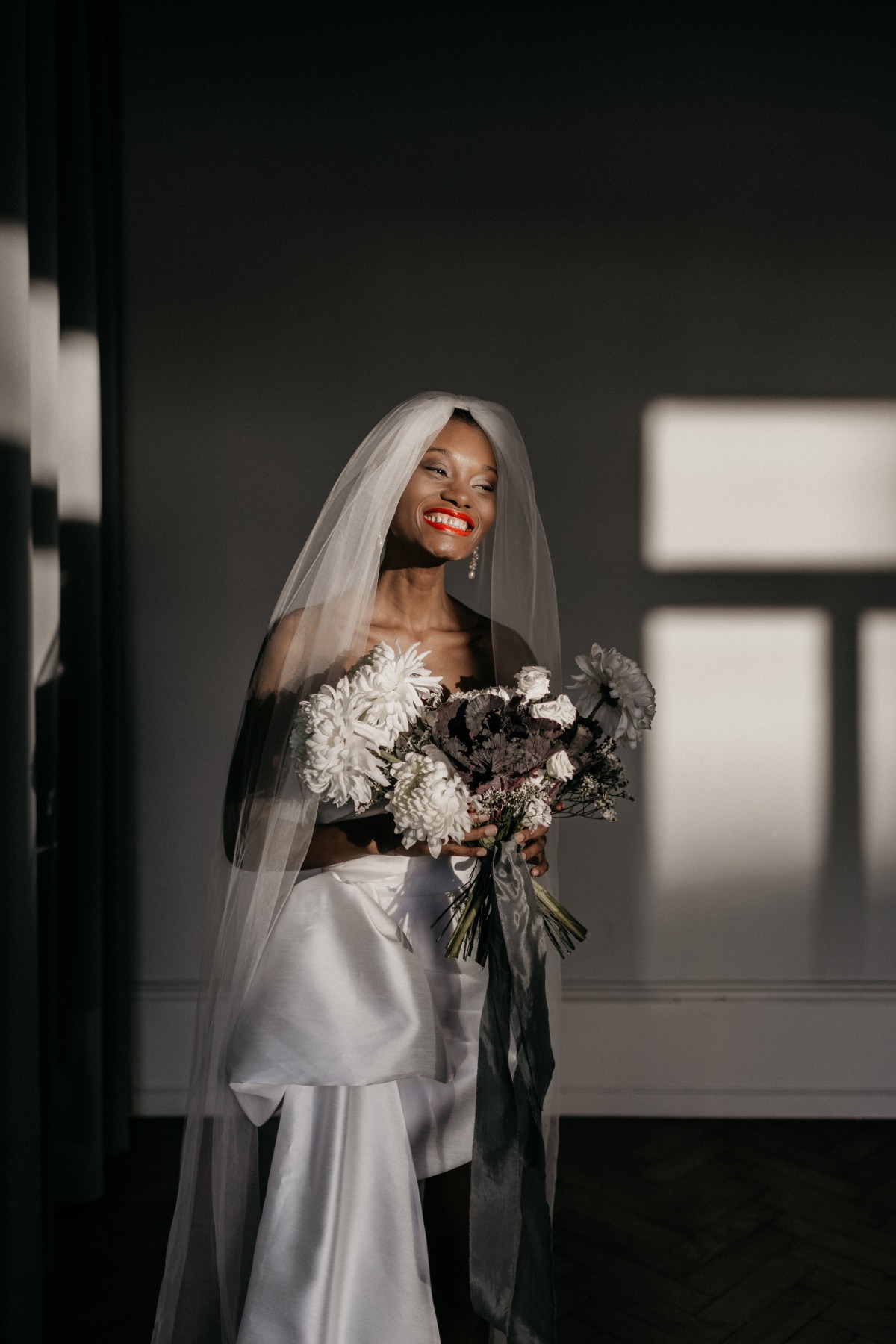 Glowing Black bride in red lipstick with long veil 