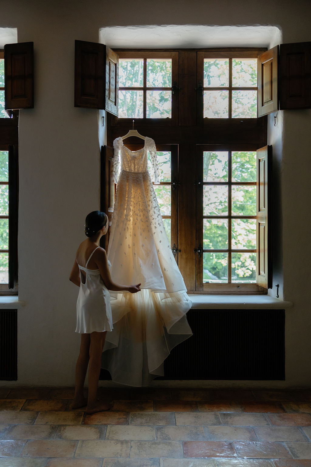 Bride admiring luxury wedding gown at French chateau