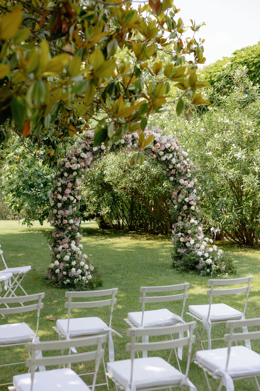 Gorgeous pink and white wedding ceremony arch and chairs