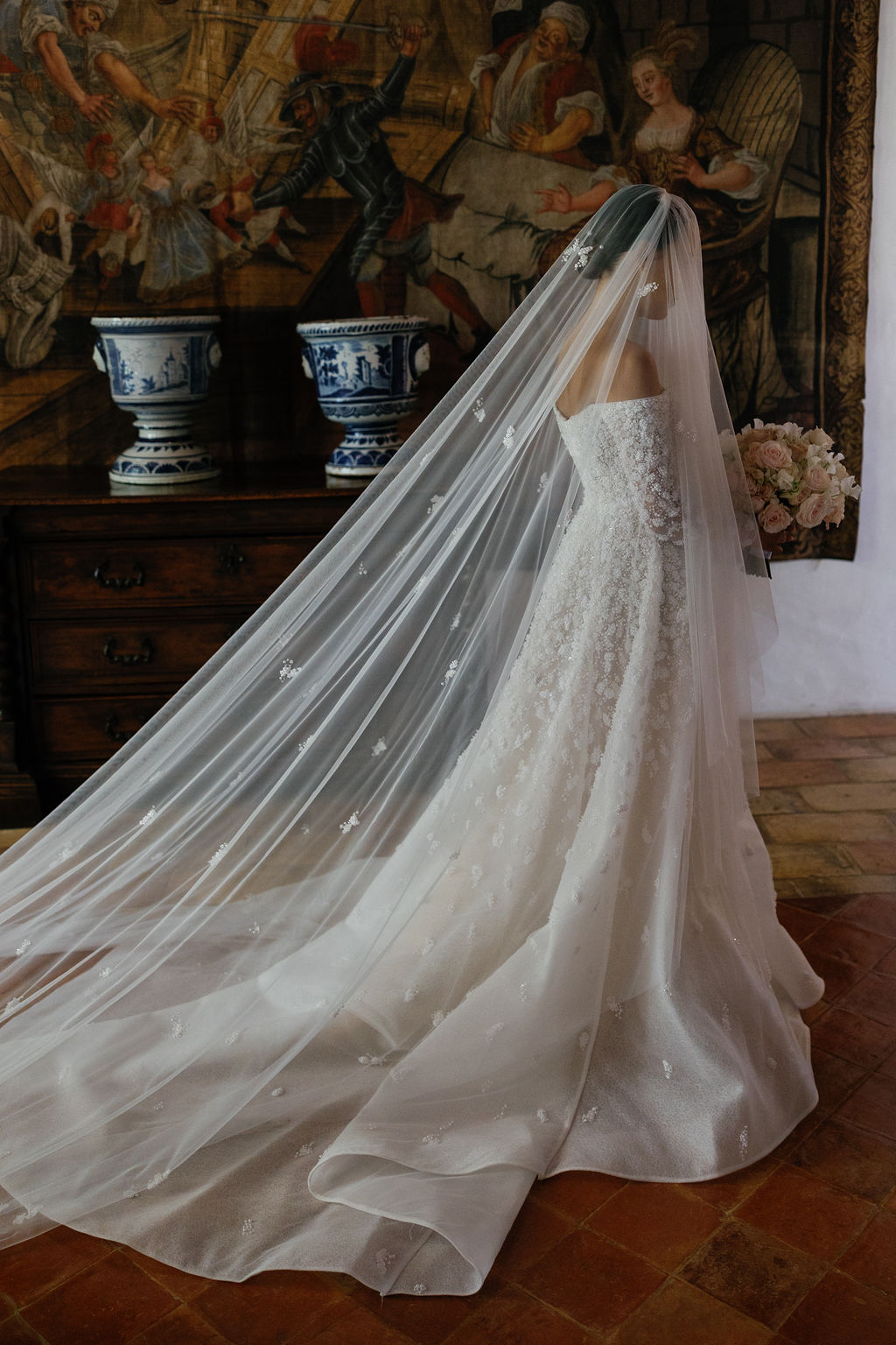Bride in floral designer wedding gown and veil that match flowers
