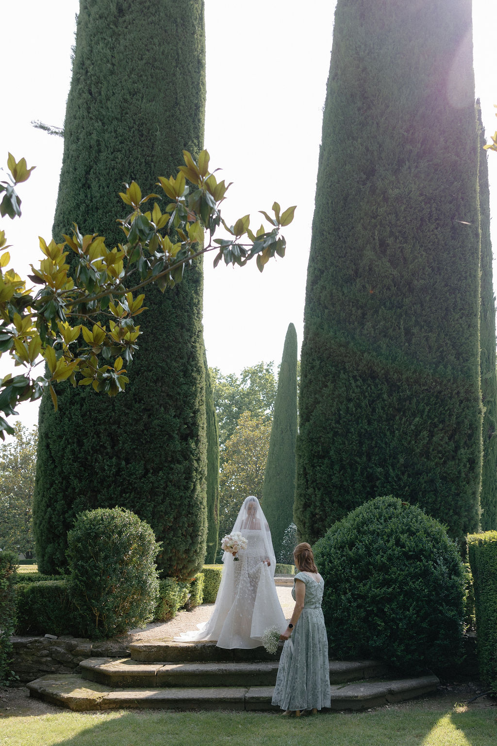 Bride walking down impressive garden aisle at chateau wedding