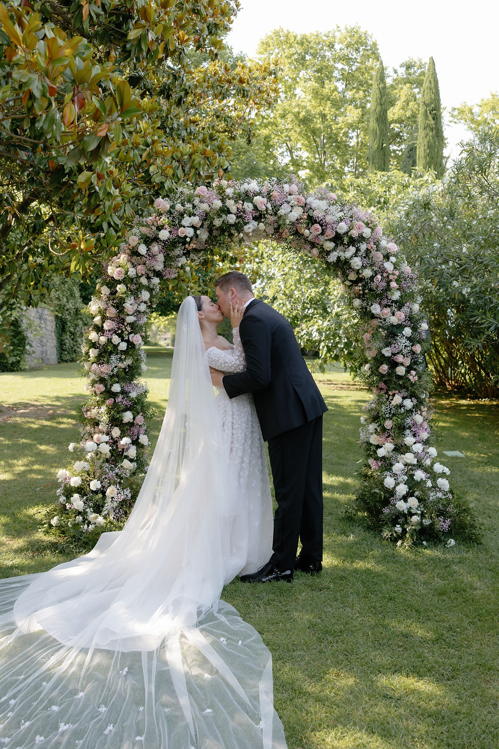 Romantic first kiss at rose garden wedding in France 