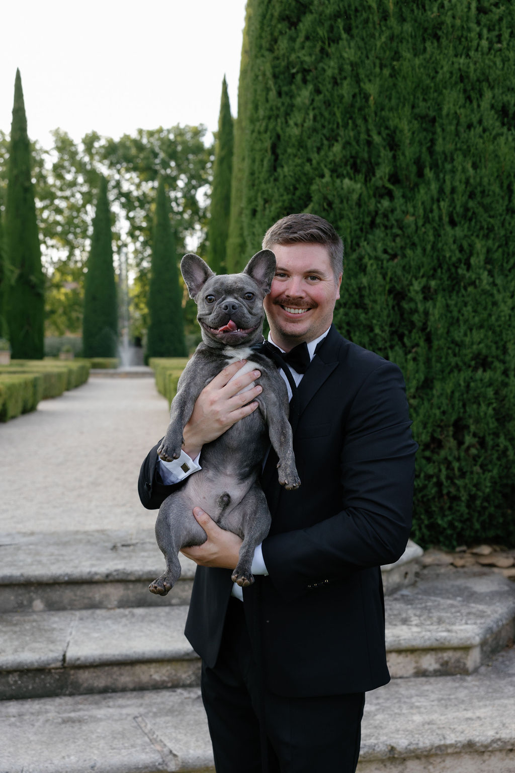 Groom with French Bulldog dog ring bearer at chateau wedding